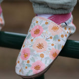 A close up of a child wearing the Inch Blue wildroses shoes available at Babipur showing the cute pastel floral design and pink ankle cuff detail