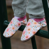 A close up of a child standing on a ladder and wearing the Inch Blue wildroses shoes available at Babipur showing the cute pastel floral design and pink ankle cuff detail