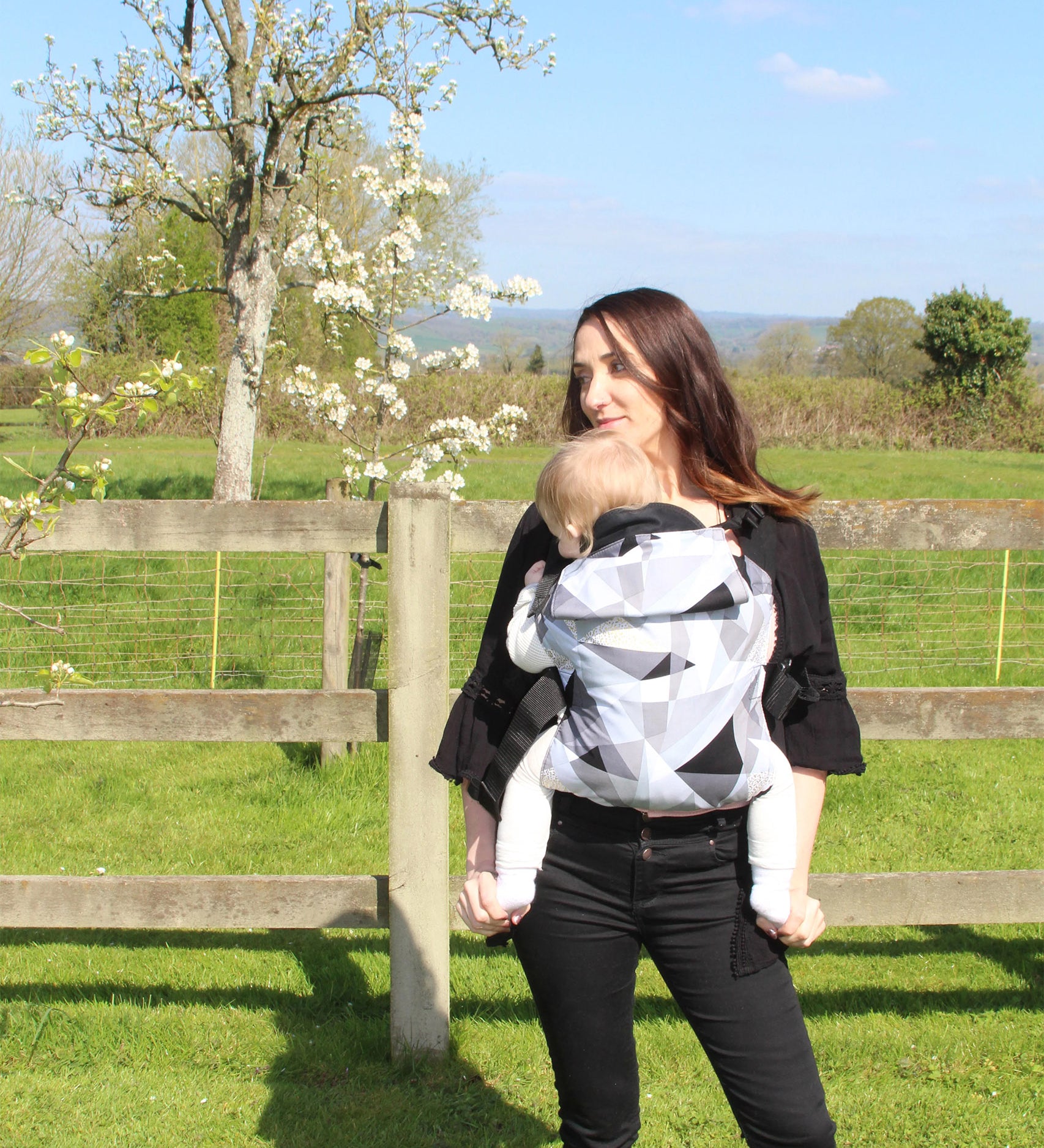 A person baby-wearing a child in an Integra Size 2 Carrier whilst outside