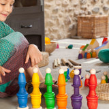 A child playing with Grapat wooden toys, Nins, spools, mates and coins have been stacked on top of each other. Grapat have a wide range of wooden toys and loose parts available at Babipur. 
