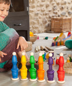 A child playing with Grapat wooden toys, Nins, spools, mates and coins have been stacked on top of each other. Grapat have a wide range of wooden toys and loose parts available at Babipur. 