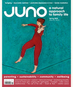 Cover of Juno Magazine Issue 95 Spring 2025. The artwork of this natural parenting magazine features an oil painting of a lady holding a naked baby on a tight rope.