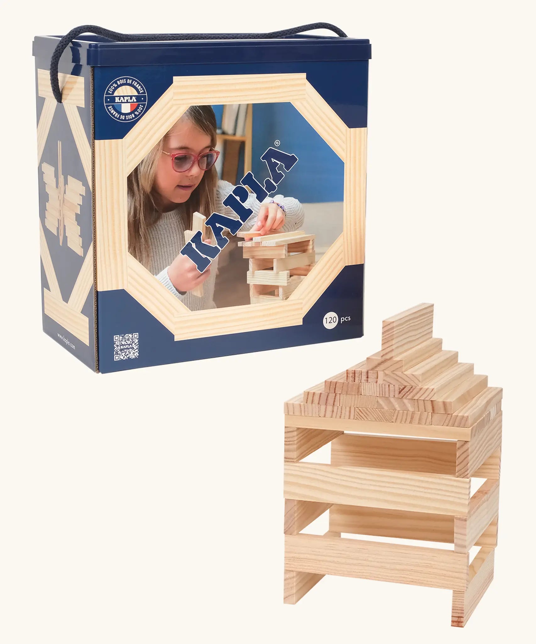 A box of 120 Kapla natural wooden construction planks. A stack can be seen next to the box 