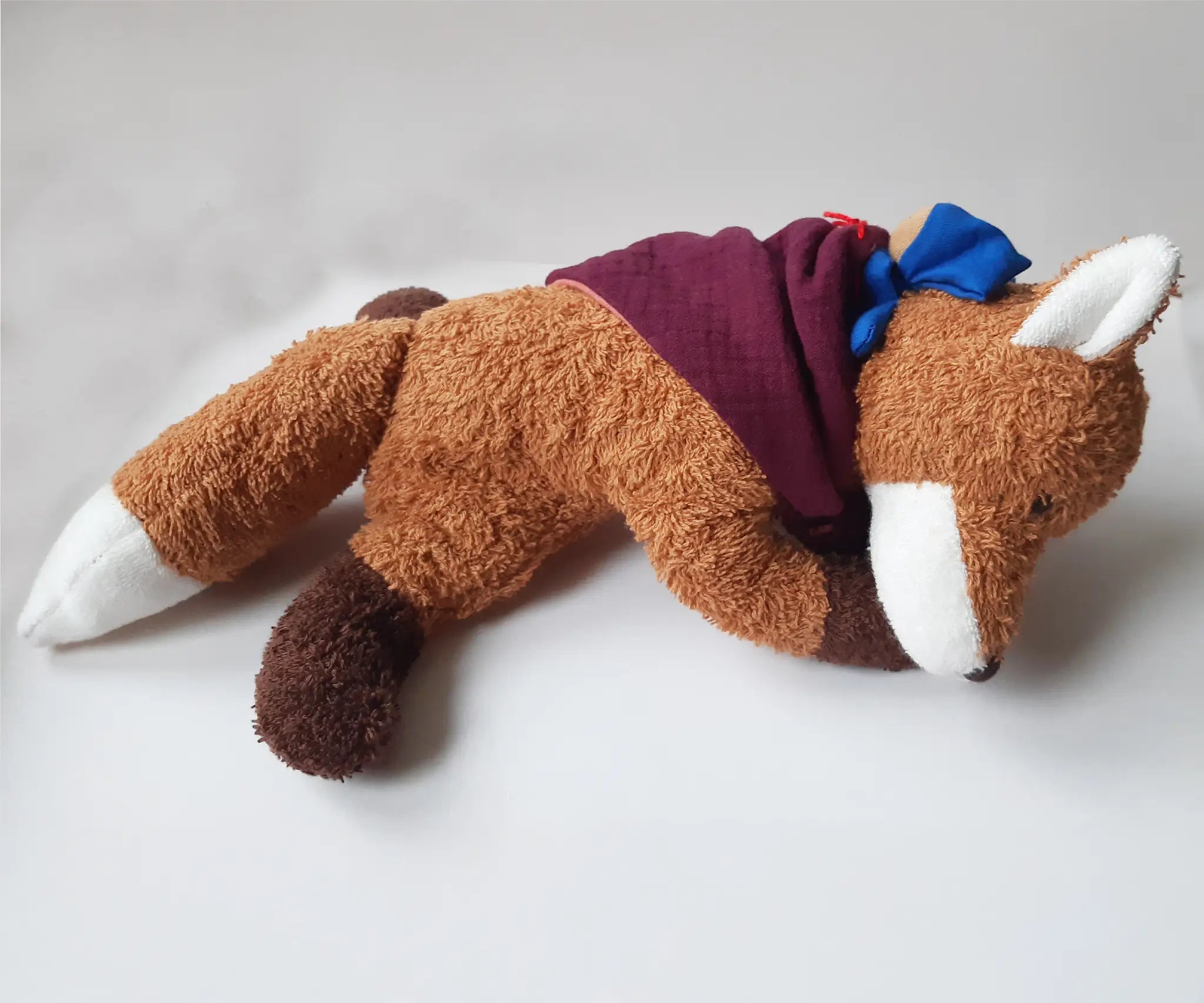 Kathe Kruse Finn the fox comforter with small blue waldorf doll on the back wrapped in the muslin bib