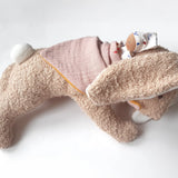 Kathe Kruse holly lying rabbit comforter with small white waldorf doll on the back wrapped in the muslin bib