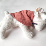 Kathe Kruse white lying lamb comforter with small white waldorf doll on the back wrapped in the muslin bib