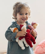 Child holding three Kathe kruse Lolo Waldorf dolls