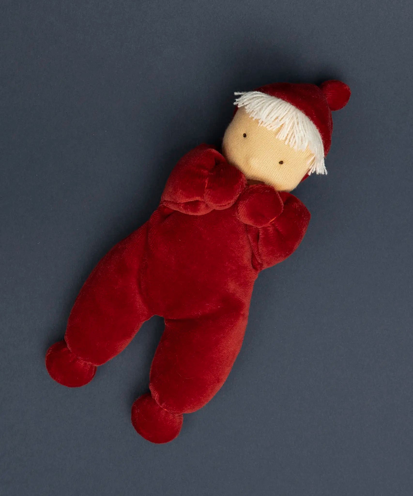 Kathe Kruse Lolo Ruby Waldorf doll lying on a navy surface