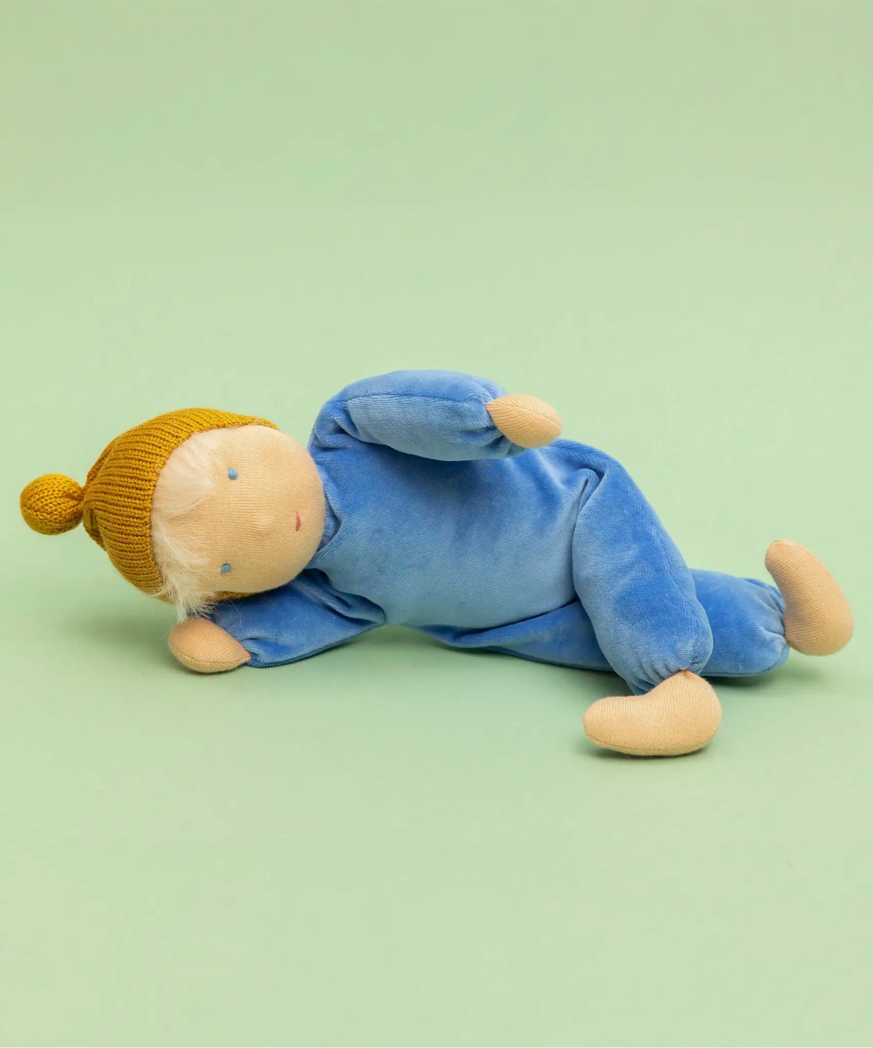 Kathe Kruse cloud nana waldorf doll lying on a green surface