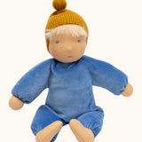 Kathe Kruse cloud nana waldorf doll showing a blue outfit and mustard yellow knitted hat, light skin and hair