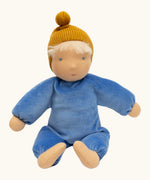 Kathe Kruse cloud nana waldorf doll showing a blue outfit and mustard yellow knitted hat, light skin and hair