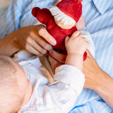 Mother and baby playing with Kathe Kruse Lolo Ruby Waldorf doll showing its red outfit and white hair
