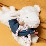 Kathe kruse white lying lamb soft comforter holding a white waldorf doll and wearing a blue muslin bib