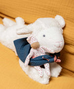 Kathe kruse white lying lamb soft comforter holding a white waldorf doll and wearing a blue muslin bib