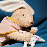 Kathe Kruse holly lying rabbit comforter holding a small white waldorf doll 