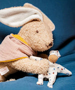 Kathe Kruse holly lying rabbit comforter holding a small white waldorf doll 