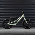 The side of the Early Rider Charger Balance Bike - Sage Green on a grey background
