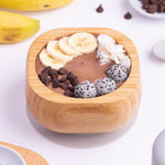 A chocolate desert with fresh banana slices in the Eco Rascals Bamboo Bowl & Spoon Weaning Set in grey silicone.