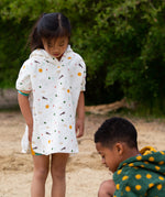 Two children playing at the beach, with the child on the left wearing the LGR Adventure Hooded Beach Towel Poncho