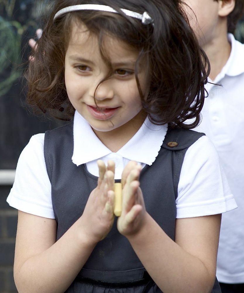 A little girl wearing the Eco Outfitters organic and fair trade cotton school pinafore dress in grey.