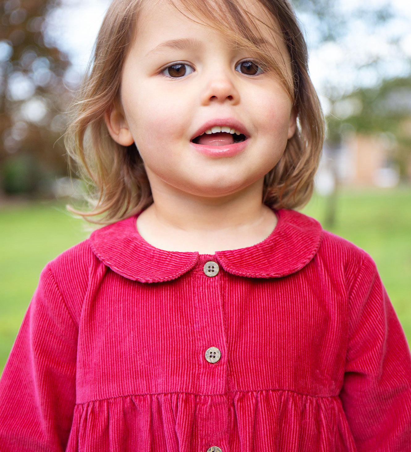 A closer look at the buttons and collar on the Frugi Coco Cord Dress - Lingonberry/Squirrel