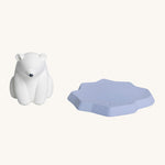 The Oli & Carol Polar Bear Bath Toy is stood next to its floating iceberg part to the right hand side. The image is on a cream background