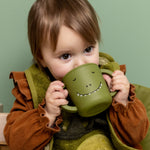 Baby drinking from the Trixie Animal Friends Silicone Sippy Cup, green, Mr Dino.