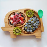 Elephant bamboo baby weaning plate with frozen berries on fruit loaf with a green silicone and bamboo baby spoon.  