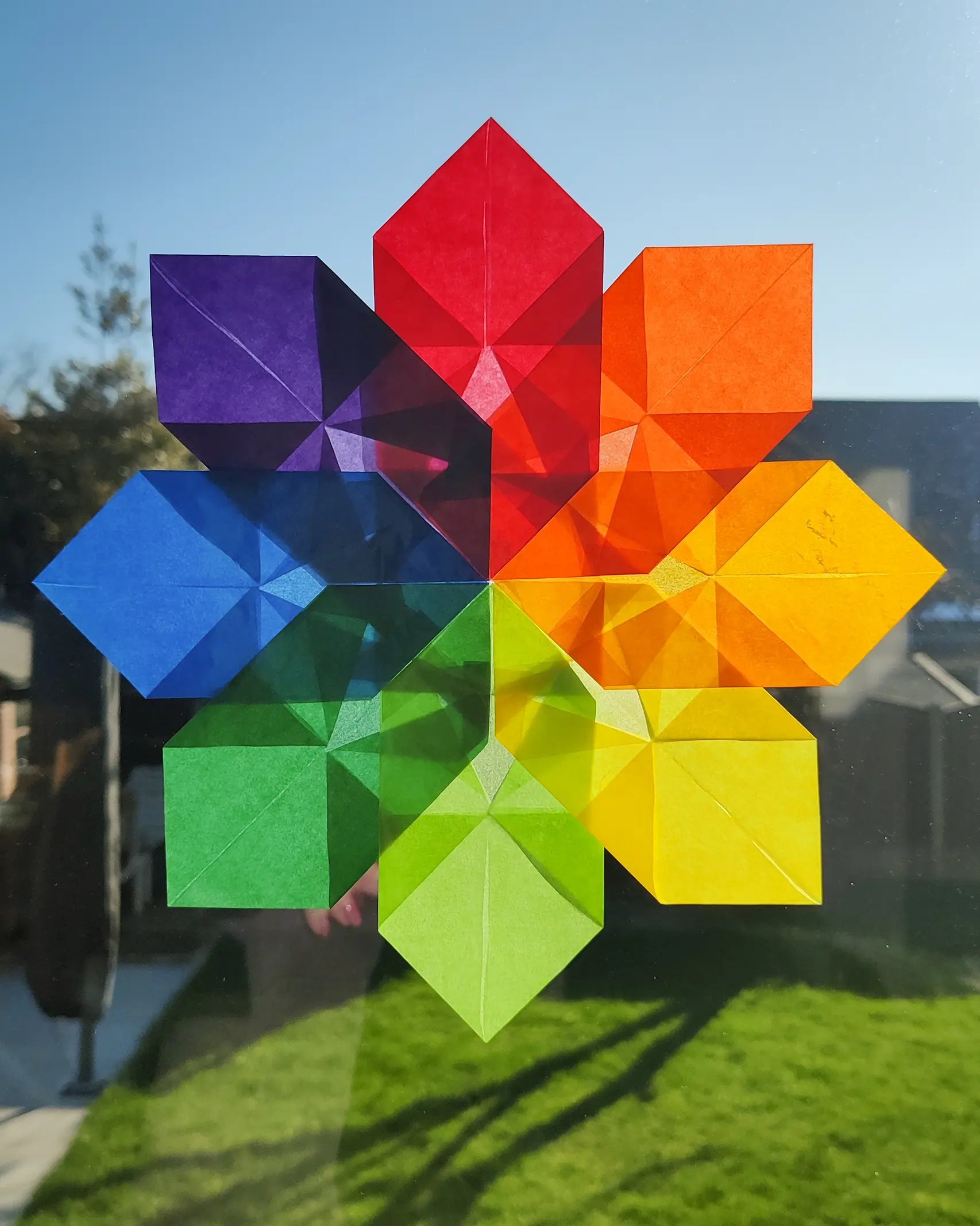 Kite Waxed Paper sunflower craft, an origami flower in rainbow Waldorf colours.