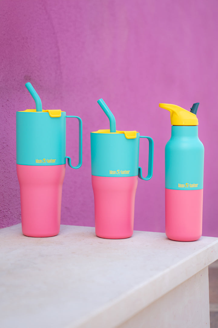 Klean Kanteen Limited Edition Turquoise Kaleidoscope Rise Collection: 36oz and 26oz insulated tumblers with a straw and handle, next to a reusable insulated bottle with a leakproof flip seal straw cap, all in a pink, turquoise and yellow colour block to represent Klean Kanteen Rise Collection at Babipur.