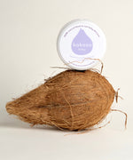 Kokoso baby organic coconut oil tub standing on a whole coconut. Tub available at Babipur 