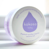 A close up of a Kokoso baby organic coconut oil tub on it's side showing the branding on the white lid. Tub available at Babipur.