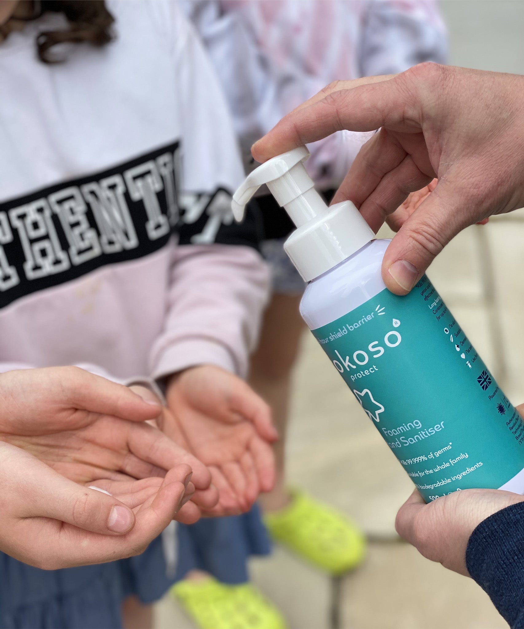 A close up of an adult hand dispensing the Kokoso protect foaming hand sanitiser from the 500ml bottle available at Babipur.