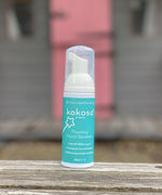 Kokoso protect foaming hand sanitiser original 50ml bottle standing on a wooden surface. Bottle available at Babipur 