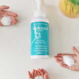 kids hands with the Kokoso protect foam hand sanitiser with the 500ml bottle in the middle. Bottle available at Babipur.