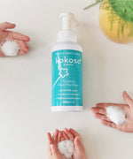 kids hands with the Kokoso protect foam hand sanitiser with the 500ml bottle in the middle. Bottle available at Babipur.