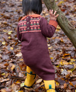 A close up of a child wearing the dark maroon Little Green Radicals collecting flowers knitted collar dress showing the button fastener and the retro flower design detail.