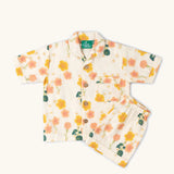 Little Green Radicals organic cotton children's short pyjamas set in cream with a pink and yellow flora print. 
