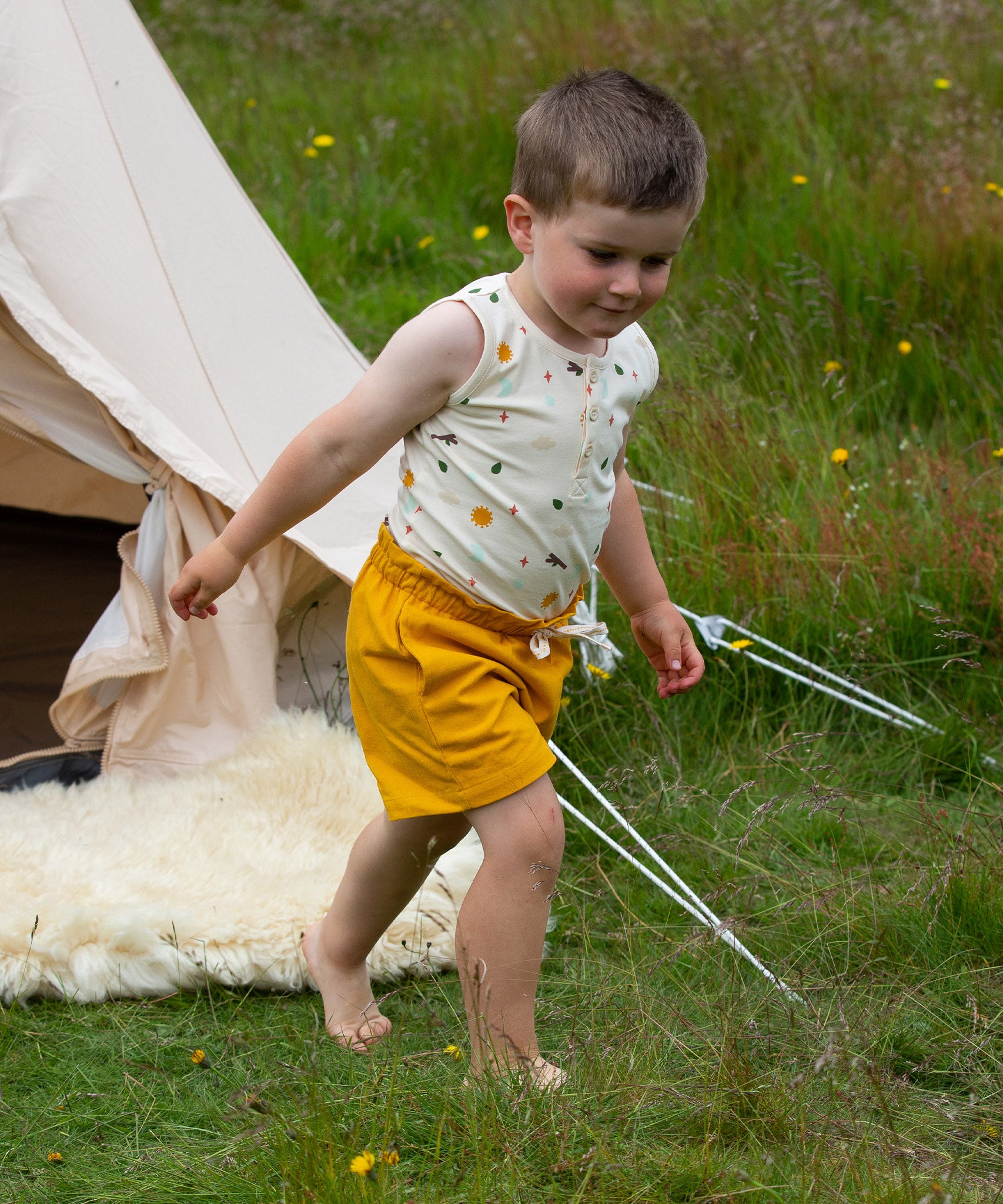 A child wearing the Adventure Print vest top, from the LGR Adventure Organic Vest Set - 3 Pack