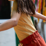 A child wearing the yellow stripe vest top, rom the LGR Adventure Organic Vest Set - 3 Pack
