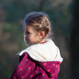 Close up of the lined hood on a Little Green Radicals pink flowers purple organic cotton sherpa toasty coat.