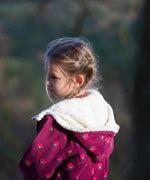 Close up of the lined hood on a Little Green Radicals pink flowers purple organic cotton sherpa toasty coat.