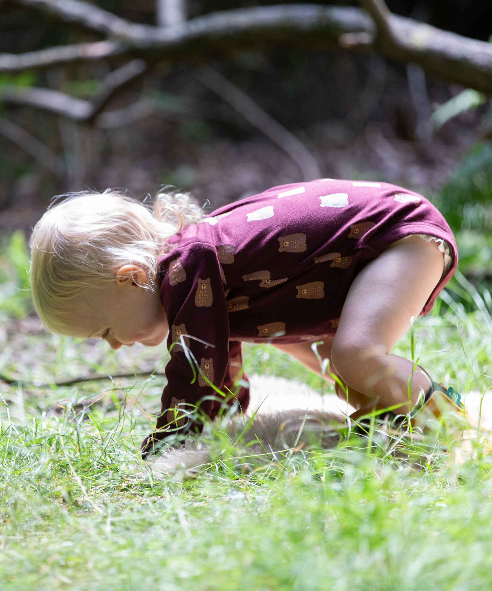 A young child on all fours on grass wearing a Little Green Radicals Baby Bodysuit 2 Pack featuring a Brown Bears print. Little Green Radicals offer a range of organic cotton children's clothing available here at Babipur. 