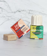 The Lamazuna Solid Face Scrub Bar and the Nourishing Lamazuna Dream Cream bar with their colourful packaging, on a white and grey marbled background
