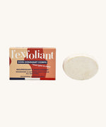 Lamazuna Solid Exfoliant Body Scrub Bar with its colourful cardboard packaging next to the bar, on a cream background