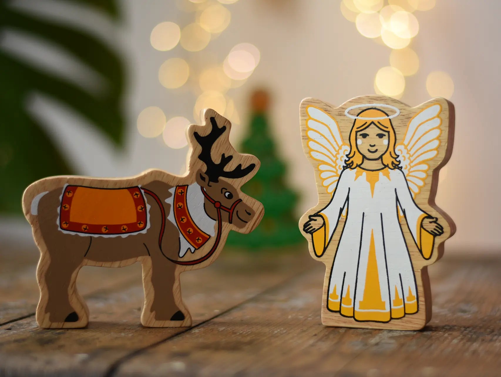 Lanka Kade Christmas angel toy with yellow and white dress, wings and halo next to a Lanka Kade reindeer with Christmas reins and seat.