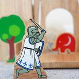 Lanka Kade blue knight with raised sword figure standing in front of a wooden castle with a tree and Babipur elephant figure