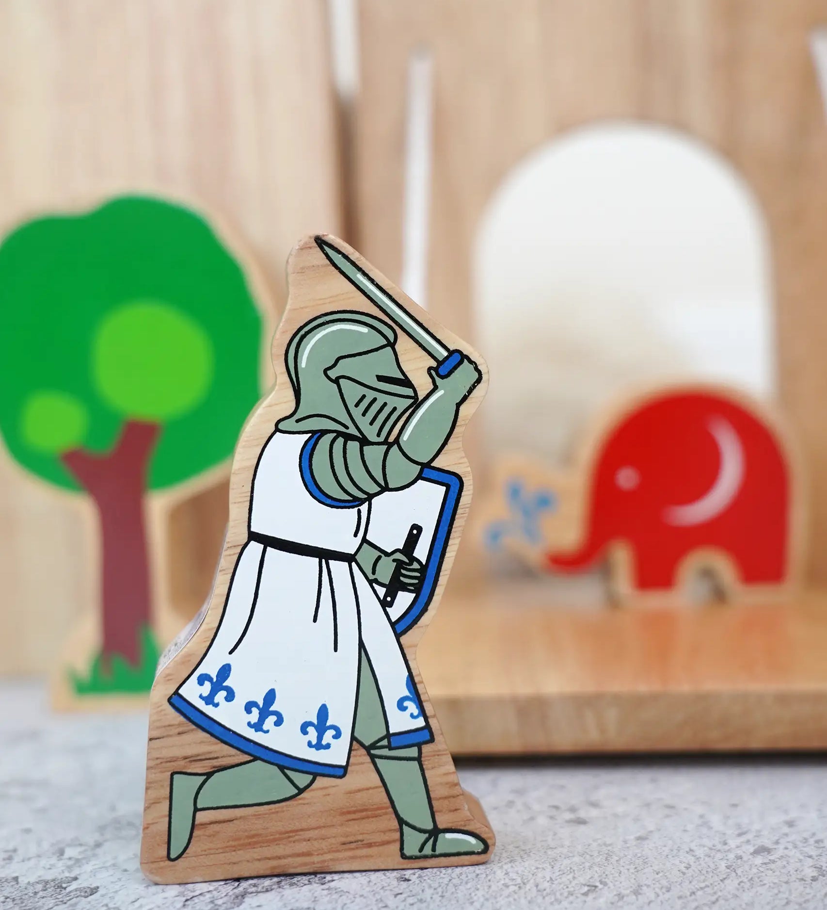 Lanka Kade blue knight with raised sword figure standing in front of a wooden castle with a tree and Babipur elephant figure