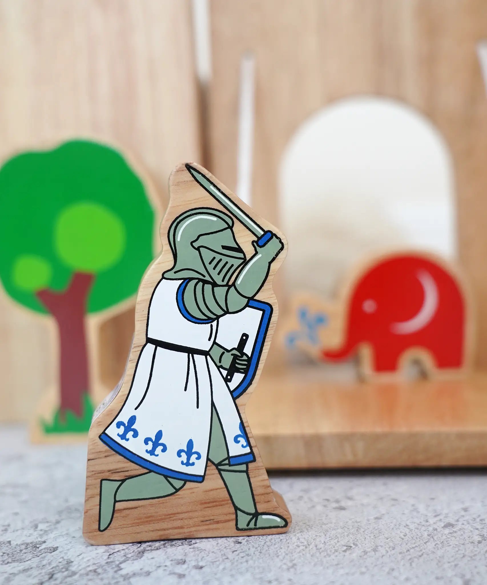 Lanka Kade blue knight with raised sword figure standing in front of a wooden castle with a tree and Babipur elephant figure