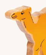 A close up of the chunky wooden Lanka Kade yellow camel figure available at Babipur. 